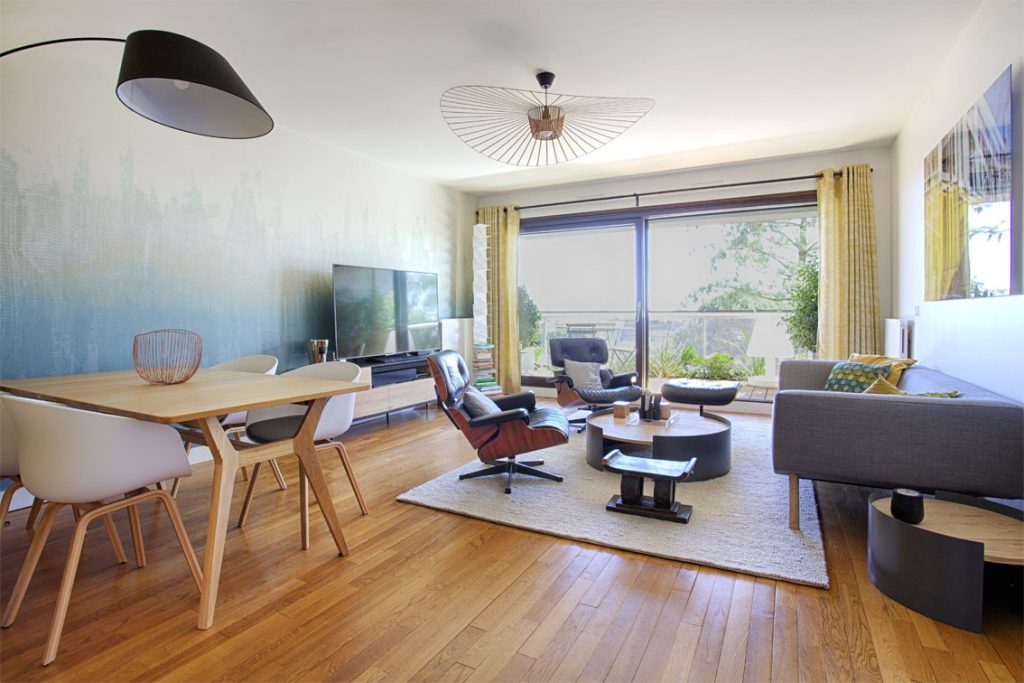 lampe arc noire, table chêne, fauteuils table blancs, parquet chêne style scandinave , meuble tv, rideaux jaune oeillets, vertigo